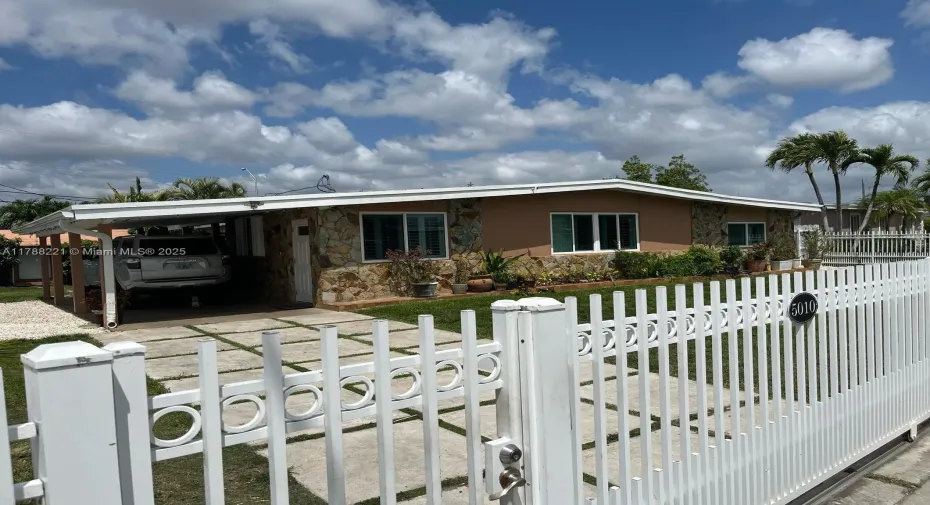 01. Facade view: Entrance, carport, electric gate, fence