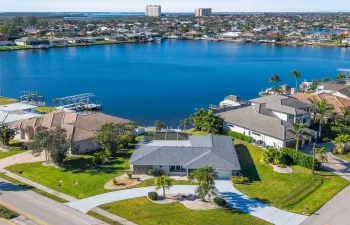 Remodeled Gulf-access home on Lake Britannia with SW views, modern kitchen, screened pool, outdoor kitchen, and prime Cape Coral location near marinas.
