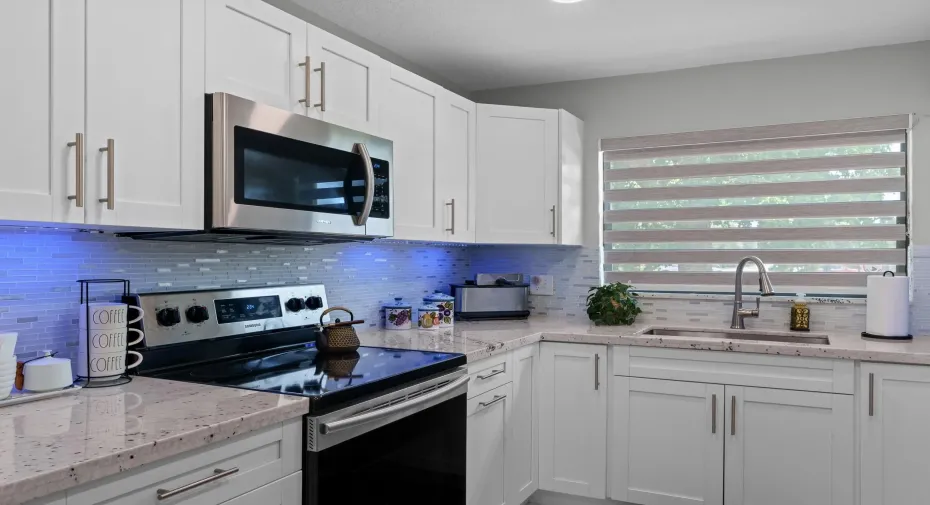 Fully remodeled eat-in kitchen features new stainless steel appliances, quartz countertops & large pantry