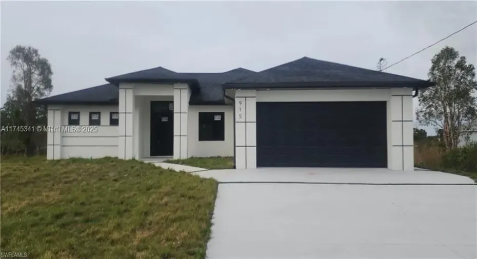 View of front façade with a garage and front lawn