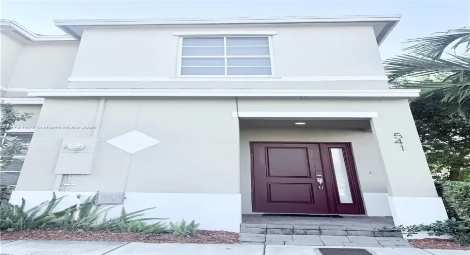 Exterior of home. Corner unit with green space next to it.