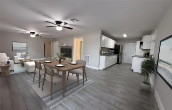 Professionally staged view showcasing the kitchen, dining area, and living room