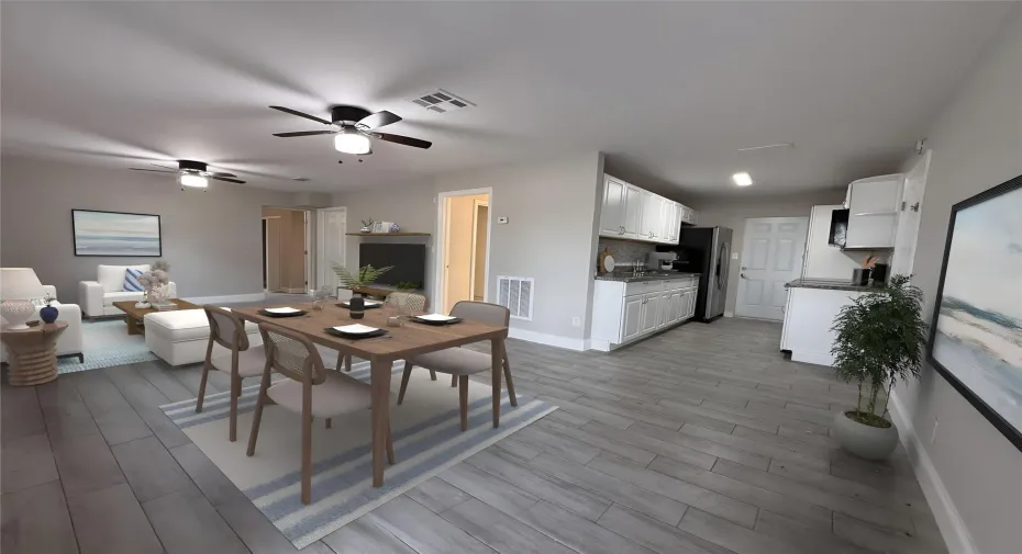 Professionally staged view showcasing the kitchen, dining area, and living room