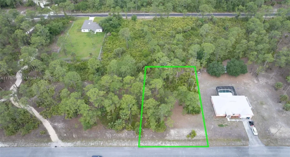 Aerial view of a buildable half-acre lot in a growing neighborhood